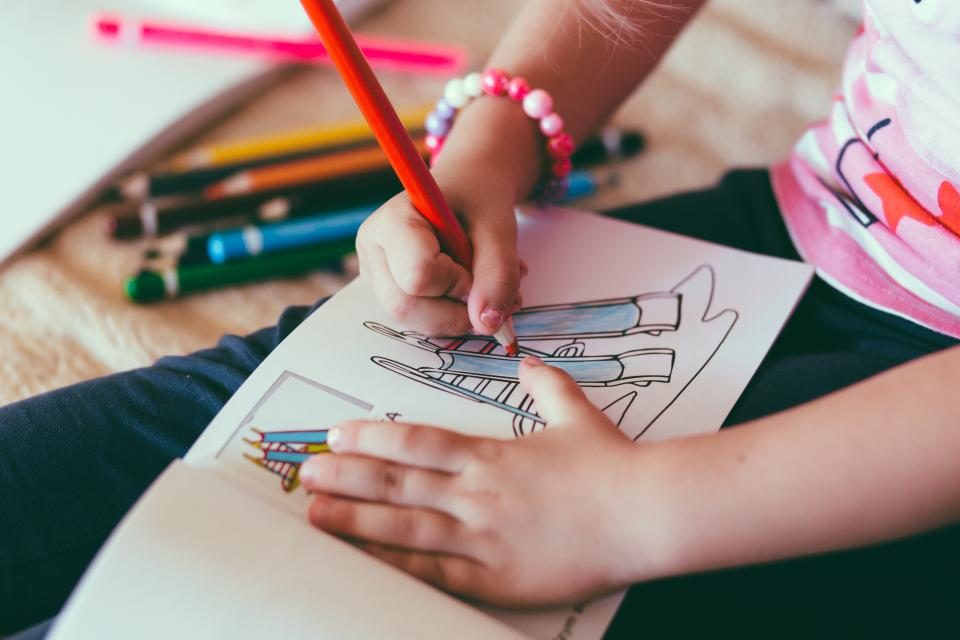Kids coloring with pencils at a table