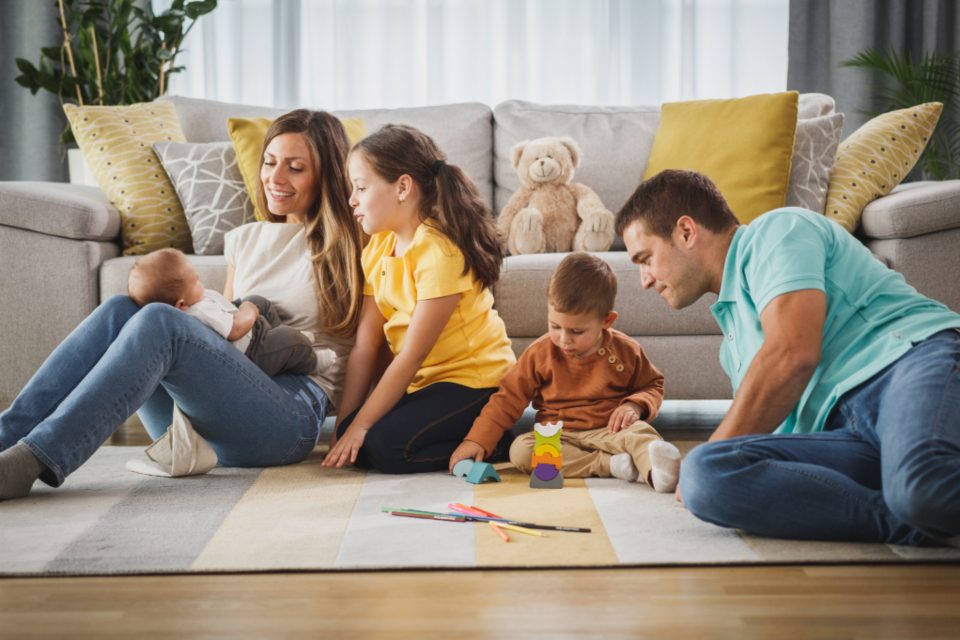 A family drawing together on the living room floor