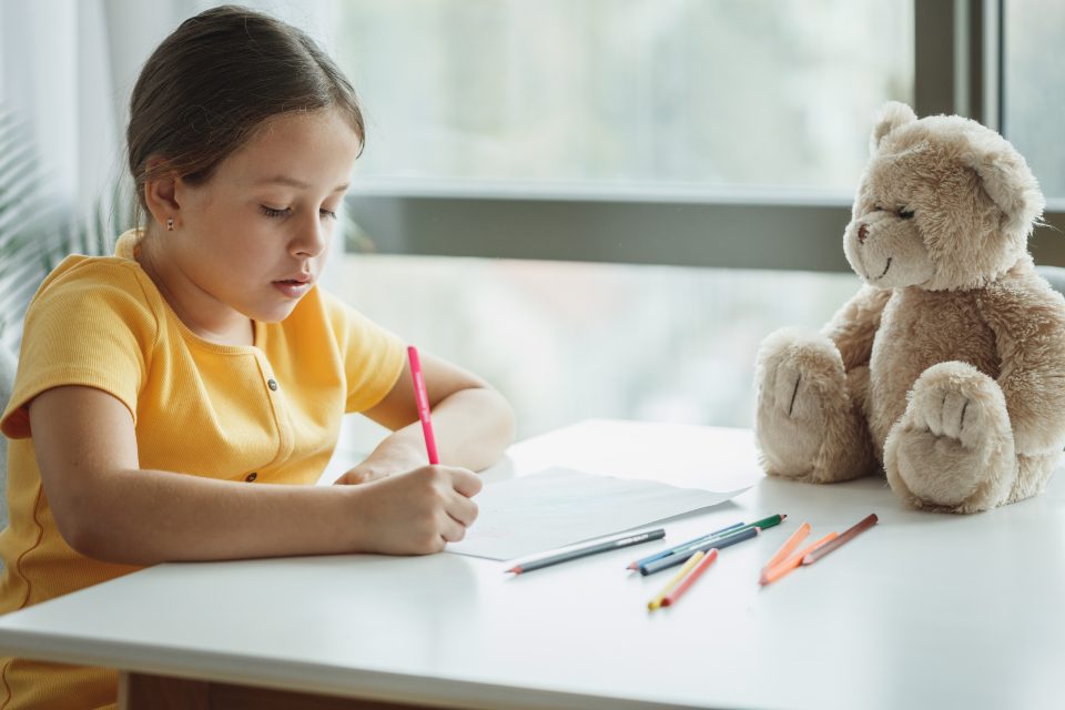 A girl writing at a desk at home